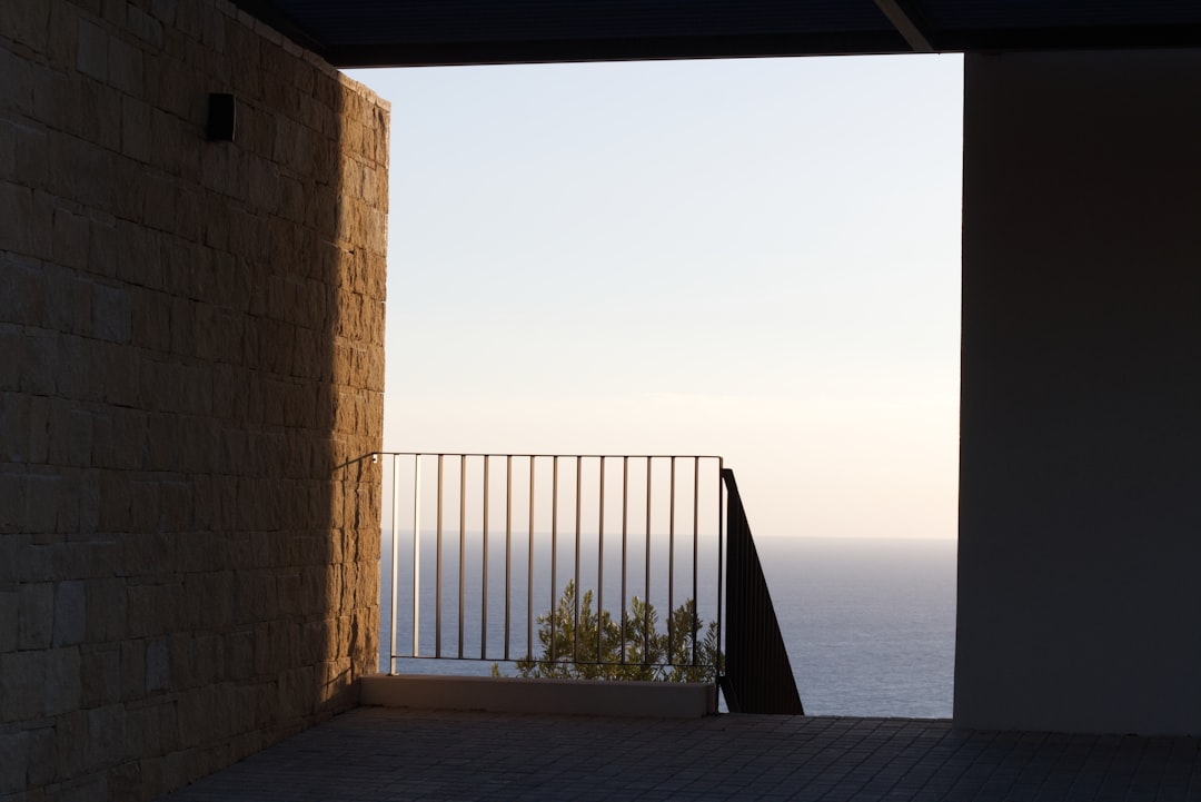 A balcony over calm water at dusk