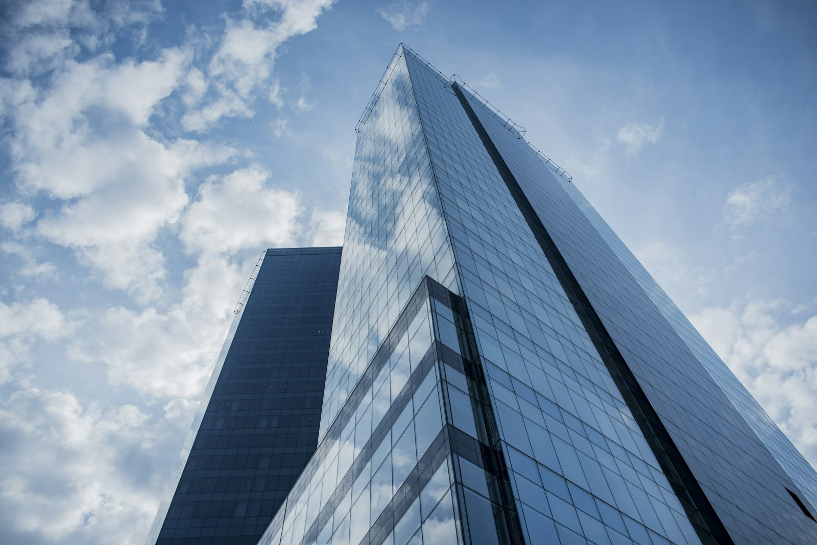 A glass residential tower seen from below
